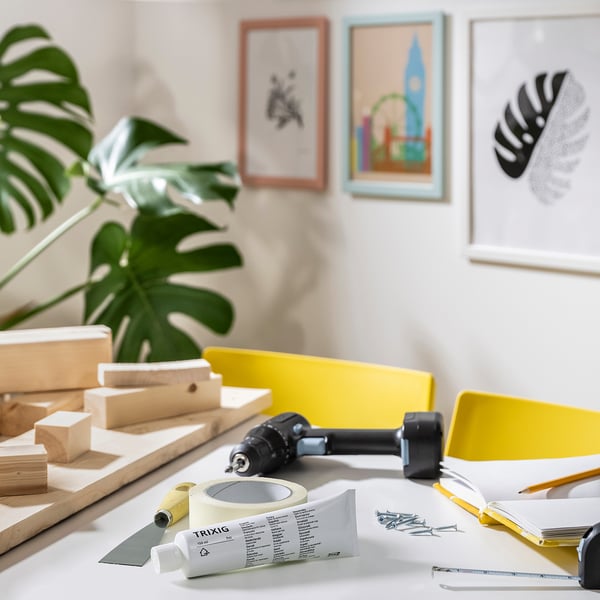 A diy workspace with TRIXIG hole repair filler, tools, and artwork.