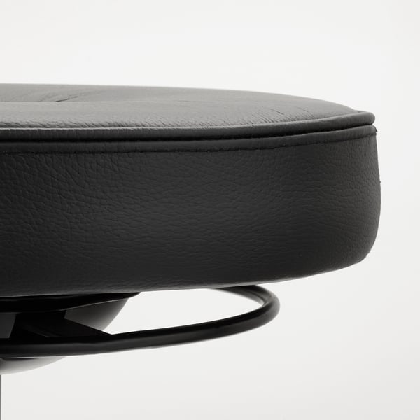 Round black leather seat with smooth finish; high-density foam, stitched edges; metal base ring partially visible.