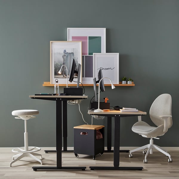 Modern home office with sit/stand desk, chair, monitor, and wall art. Desk adjustable, taller than other items.
