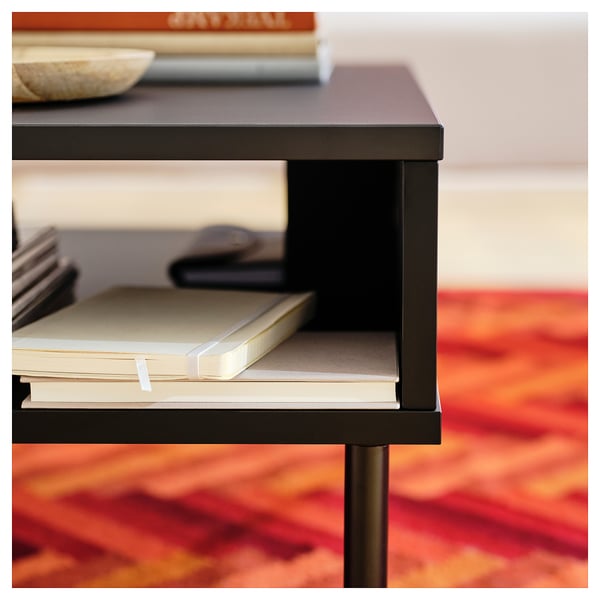 Small black side table with one shelf, holding papers. Modern and minimalist design.