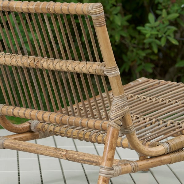 Woven outdoor lounge chair made of natural rattan, showcasing intricate craftsmanship and robust design.