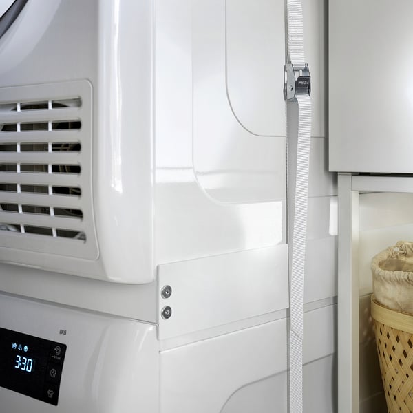 White TYKARP stacking kit securing a dryer atop a washing machine.