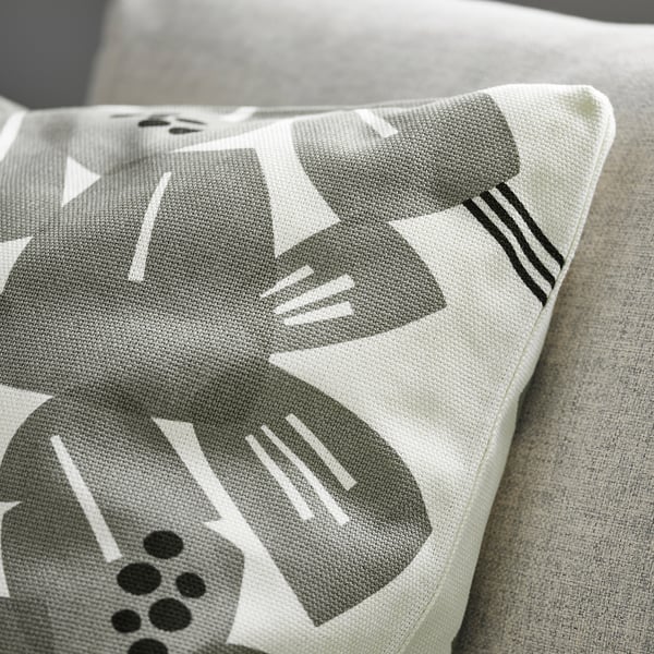 Decorative pillow on couch, white with abstract grey patterns, high-quality cotton-jute texture.
