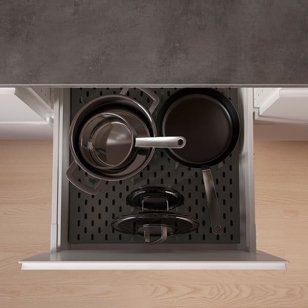 Organised kitchen drawer with black UPPDATERA pegs holding pots and pans, efficient storage solution.