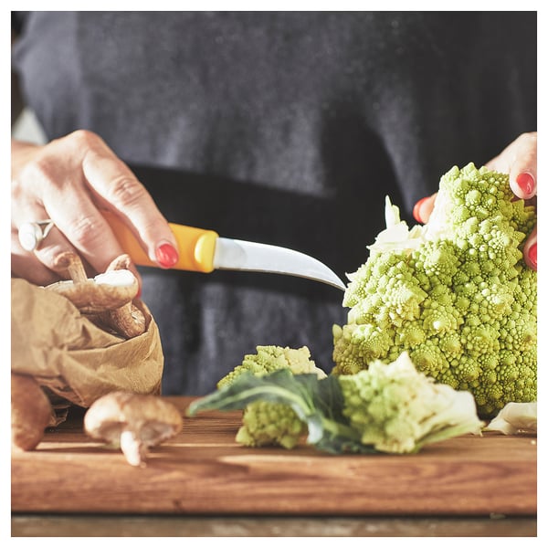 Hand cutting romanesco with orange knife