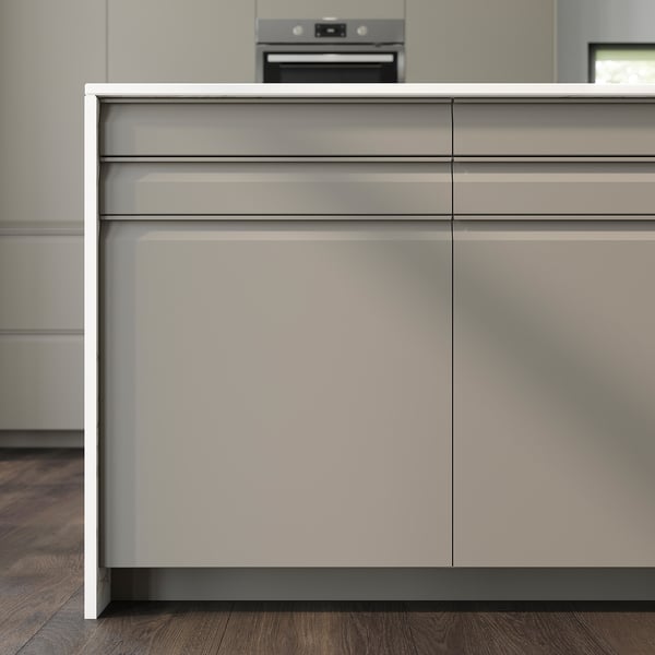 Modern beige kitchen cabinets with sleek, integrated handles and chamfered edges.