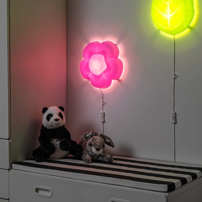 Two stuffies on striped bench, pink flower lamp, warm glow.