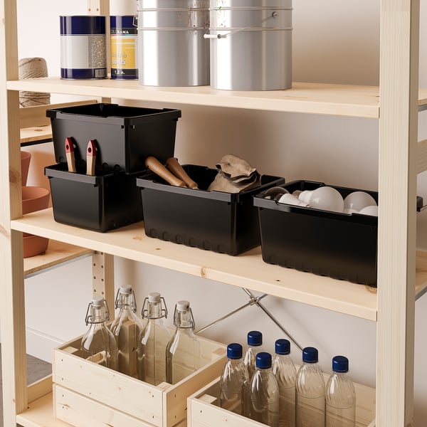 Wooden shelf with black UPPSNOFSAD boxes and glass bottles.