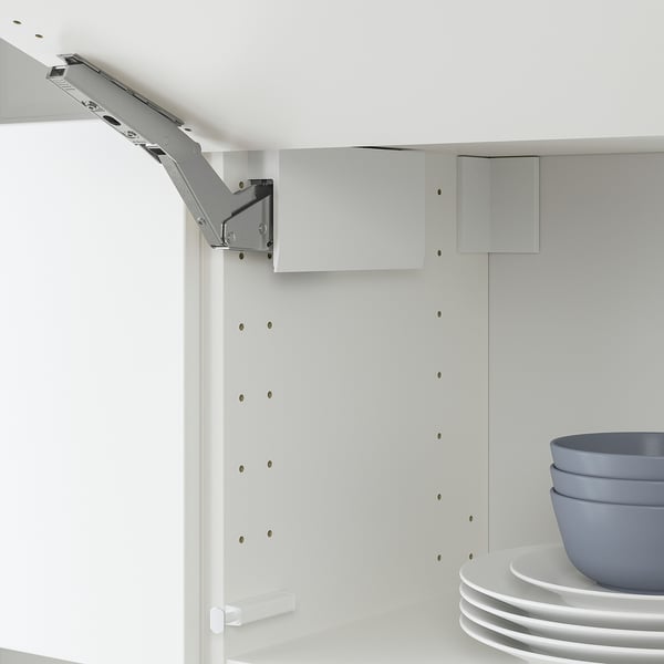White cabinet hinge with adjustable parts, grey hardware, holding blue bowls and white plates.