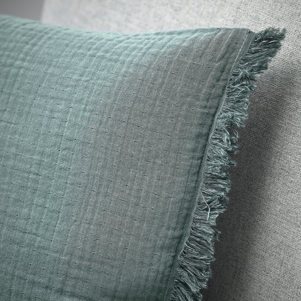 A close-up of a soft, textured fabric with visible stitching and frayed edges, showcasing high-quality craftsmanship.