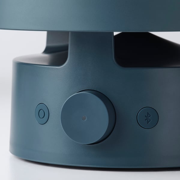 A sleek, modern blue speaker lamp with intuitive controls, featuring a central power button and bluetooth pairing icon.