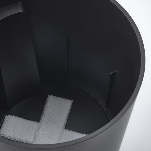 Black self-watering planter with visible water level indicator inside, part of VÅRDTRÄD series.