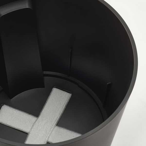 Black self-watering planter with white wicks and frosted saucer.