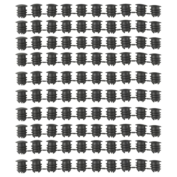 Image multiple rows of black VARIERA cabinet hole covers, displaying their cylindrical shape and ribbed design made of polyethylene plastic.