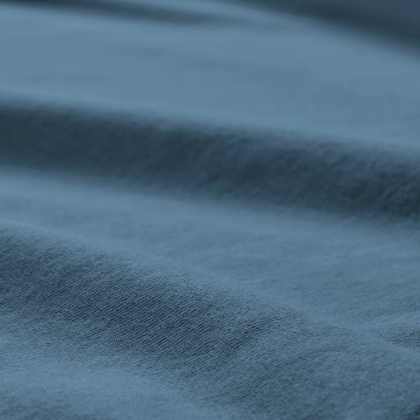 Soft, textured blue-gray cotton jersey fabric, smoothly draped, showcasing quality and comfort.