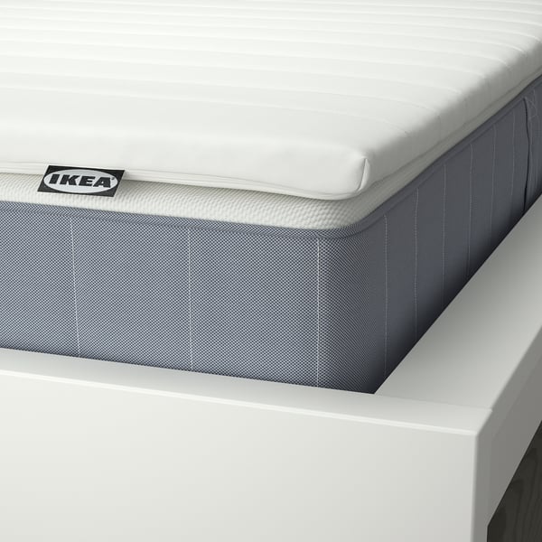 Close-up of a firm mattress from IKEA, displaying quality stitching and supportive grey material.