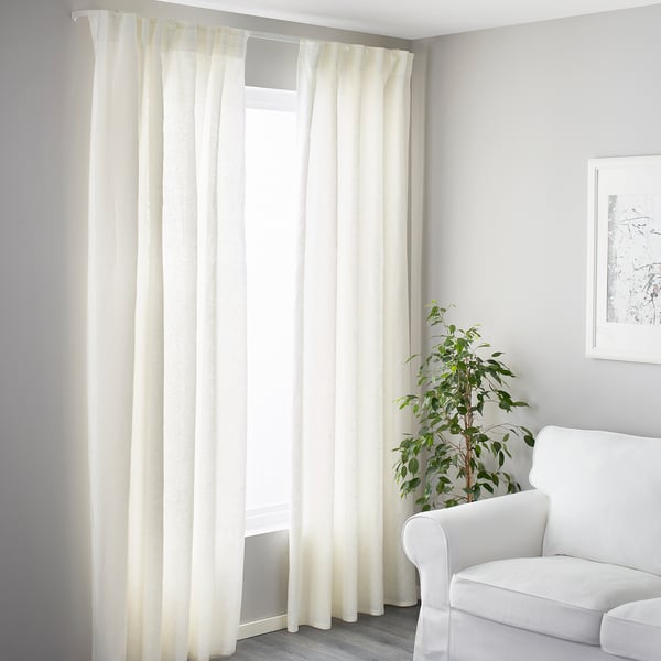 Bright room, open curtains, armchair, plant, flexible curtain rail.