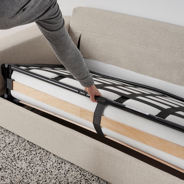 Person pulls out sofa-bed mechanism showing functional conversion of VIMLE sofa.