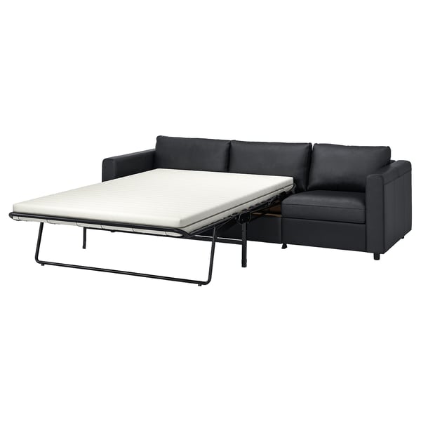 Dark grey convertible sofa with black metal frame and thick mattress, perfect for small spaces.