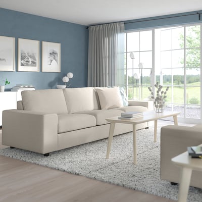Modern living room with large cream-colored VIMLE sofa, wood coffee table, grey walls, and large windows.