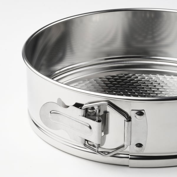 Close-up of a shiny, stainless steel springform pan with a secure clip lock, ideal for baking.