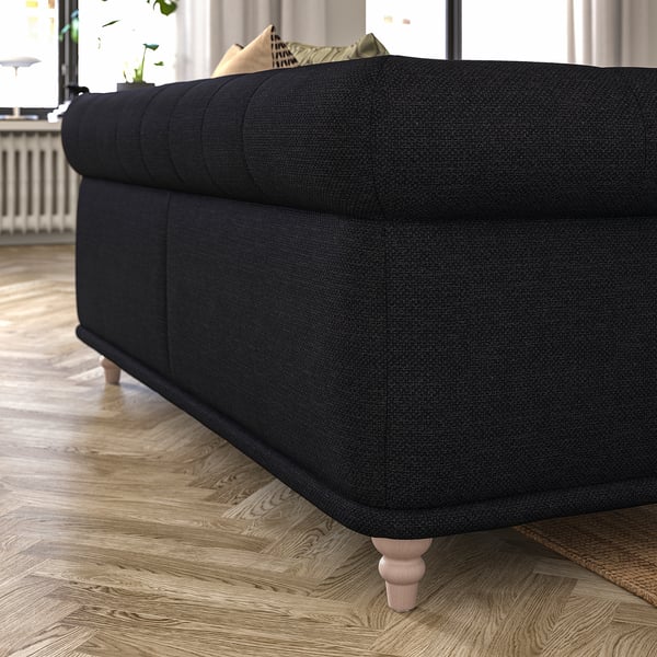 A dark grey, rounded VISKAFORS sofa with wooden legs, sitting on a wooden floor.