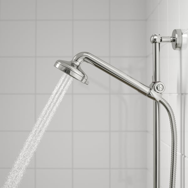 A chrome shower head with mesh and full spray functions in use, mounted on a flexible rail. Water streams down in a powerful spray.