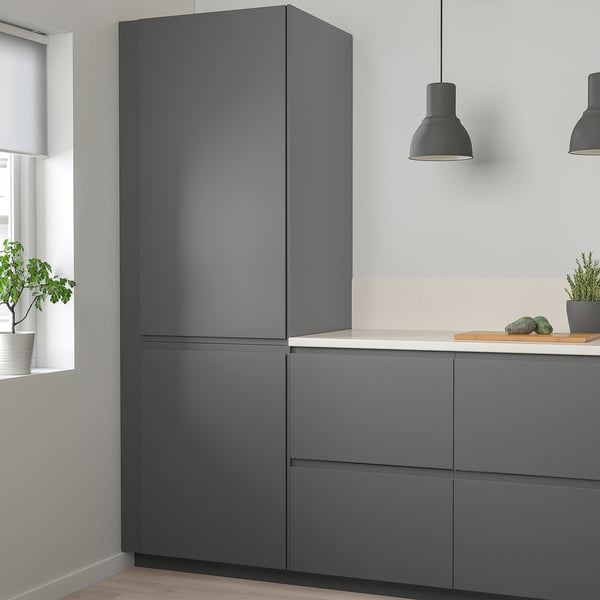 Modern kitchen with dark grey cabinets & large fridge.