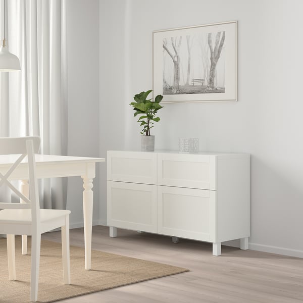 Balts BESTÅ skapis ar 4 durvīm, 2 atvilktnēm. Mūsdienīga ēdamistabas zona ar augu.