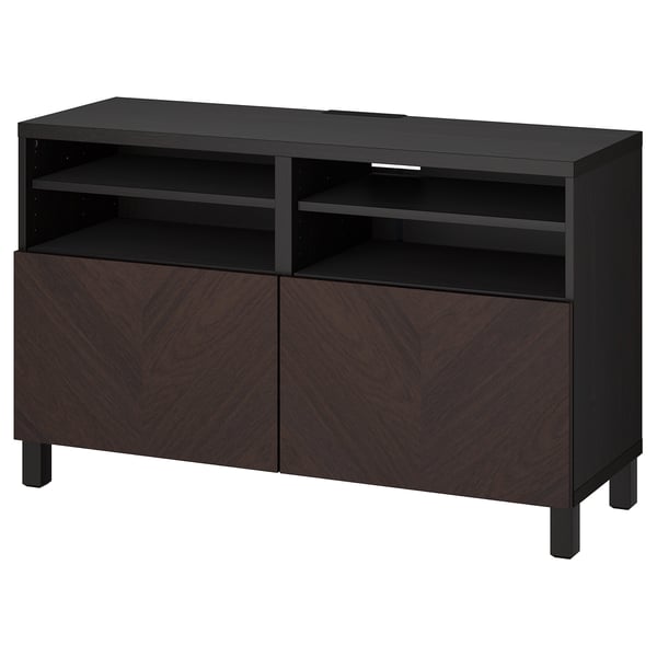 Melnbrūns ikea BESTÅ televizora sols ar ševrona durvīm un plauktiem.