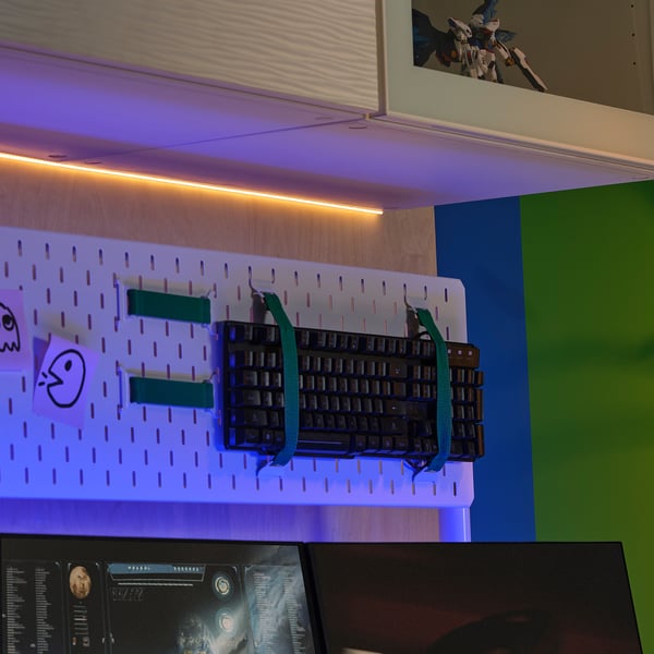 LED sloksnes gaismas virs tastatūras turētāja ar zilgankrāsas siksnām, monitors apakšā, darba vietas iestatīšana.