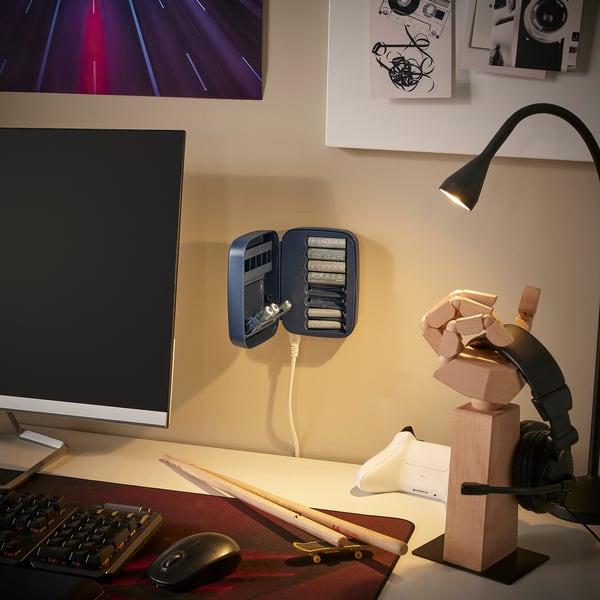 Mūsdienīga darba vieta ar LITOSFÄR lādētāju, monitoru, tastatūru, peli, skrituļdēli, austiņām un koka statuju.