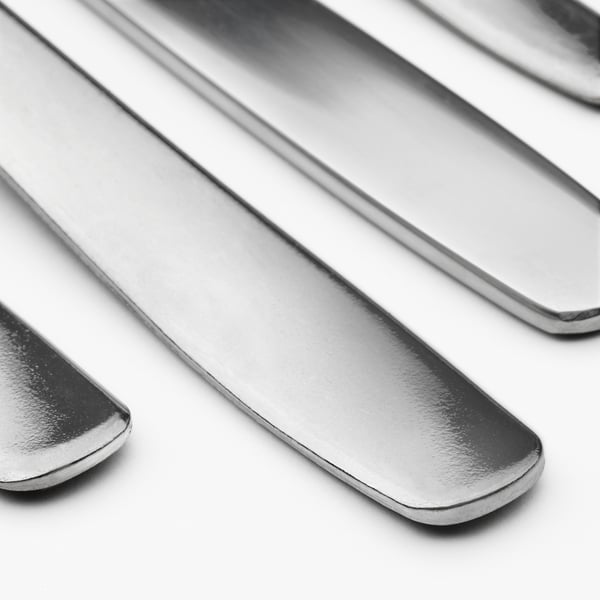 Pulētu nerūsējošā tērauda galda piederumu kaudze - dakšiņas, karotes, naži. Augstas kvalitātes, spīdīga apdare, izturīga un tīra.