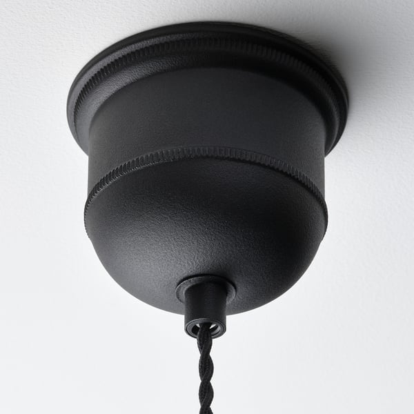 Melna piekaramā lampa ar austu dizainu karājas pie griestiem, demonstrējot augstas kvalitātes meistarību un mūsdienīgu stilu.