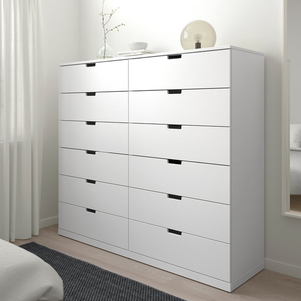 Liela balta NORDLI kumode ar sešām atvilktnēm tīrā telpā.