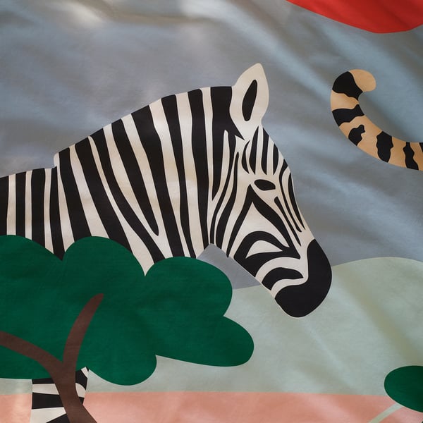 Zebras tēmas segas komplekts, spilgti krāsots, demonstrējot augstas kvalitātes audumu un sarežģītu, rotaļīgu dizainu.
