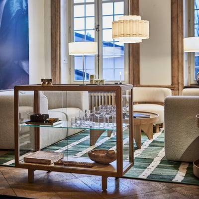 Eleganta STOCKHOLM 2025 stikla vitrīna, koks un stikls. Mūsdienīgs skandināvu dizains. Tur daudzas vīna glāzes, centrētas istabā, garš.