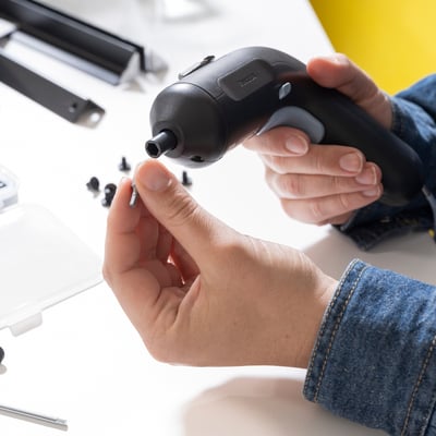 Persona, kurai ir TRIXIGs akumulatora skrūvgriezis ar magnētisku bitu turētāju un LED gaismu, kas parāda ergonomisko dizainu.