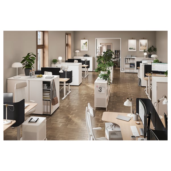 Современное офисное пространство с белой мебелью и растениями, письменными столами, стульями и шкафами для хранения с раздвижными дверями.