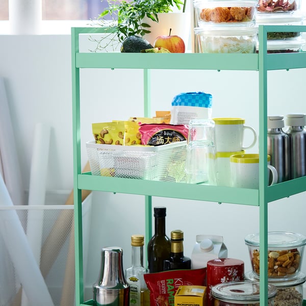 -ярусный стеллаж IKEA с растениями, продуктами, закусками и бутылками.