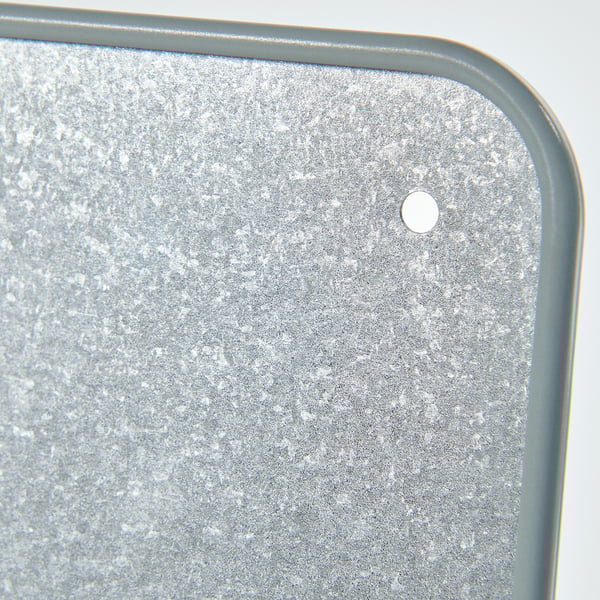 Металлический лист с мелкими выпуклыми точками и центральным круглым отверстием, обрамленным зеленой каймой.