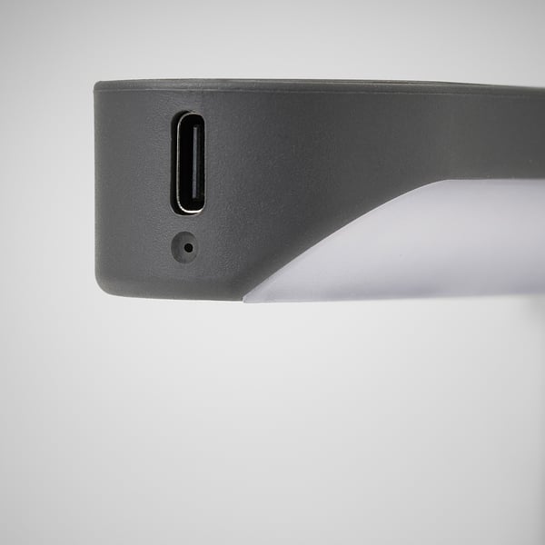 Крупный план элегантного современного аккумуляторного фонаря usb-c. Показывает порт зарядки и переключатель включения/выключения, подчеркивая качество и простоту.