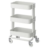Белая тележка ikea RÅSKOG с тремя полками и четырьмя колесами, предназначенная для хранения и удобной мобильности.
