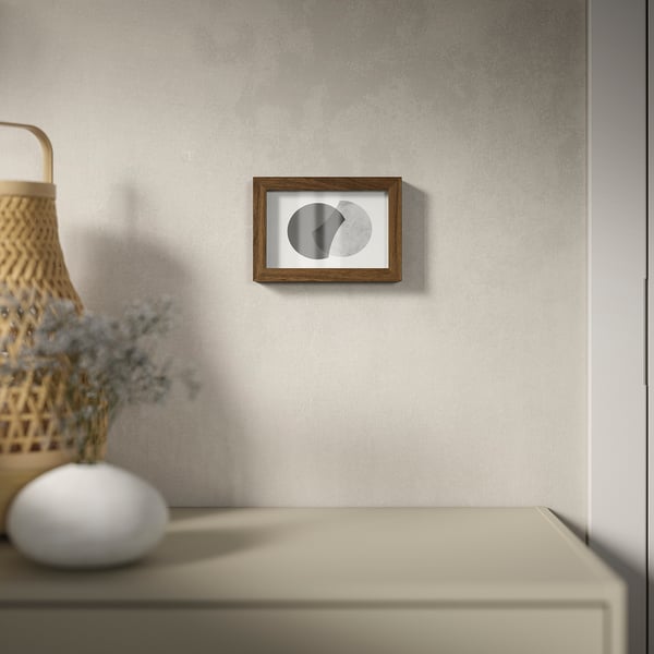 Минималистичная фоторамка с пластиковым фасадом, висит на текстурированной стене, вмещает фотографии близко или глубоко.