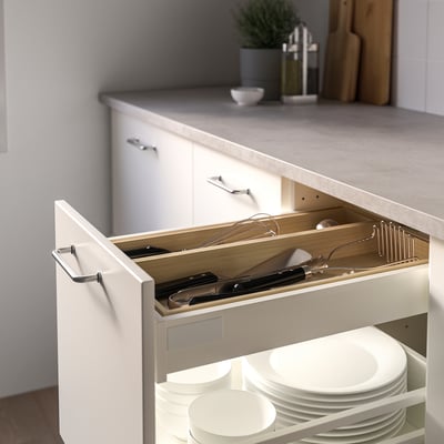 Открытый кухонный ящик с поддоном для посуды, вмещающий половники, венчики и тарелки. Лоток сохраняет предметы в порядке и предотвращает их повреждение.