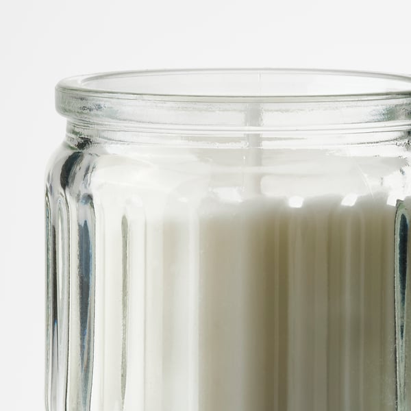 Clean, ribbed glass candle jar, clear with pale yellow wax, well-made and detailed.