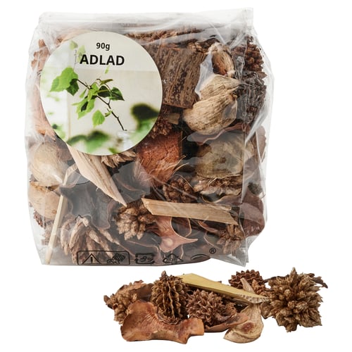 Clear plastic bag of ADLAD potpourri, featuring dried leaves and cones, brown in colour, with a circular label on the front.