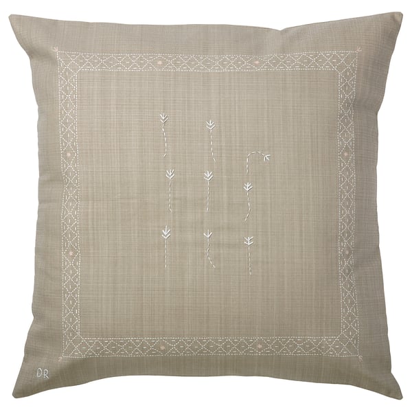 An IKEA ÅKERNEJLIKA beige square cushion cover with hand-embroidered floral designs and geometric borders, made from 100% cotton.