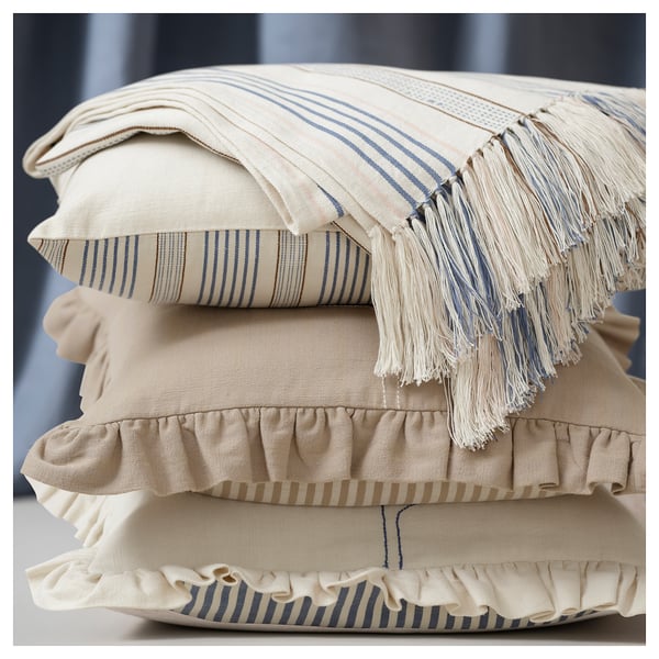 Pillow stack: beige with blue stripes, fringe, ruffles; cotton; hand-embroidered, striped designs.