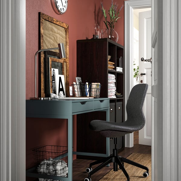 Home office with grey desk & chair vs red wall. Desk & chair highlighted.